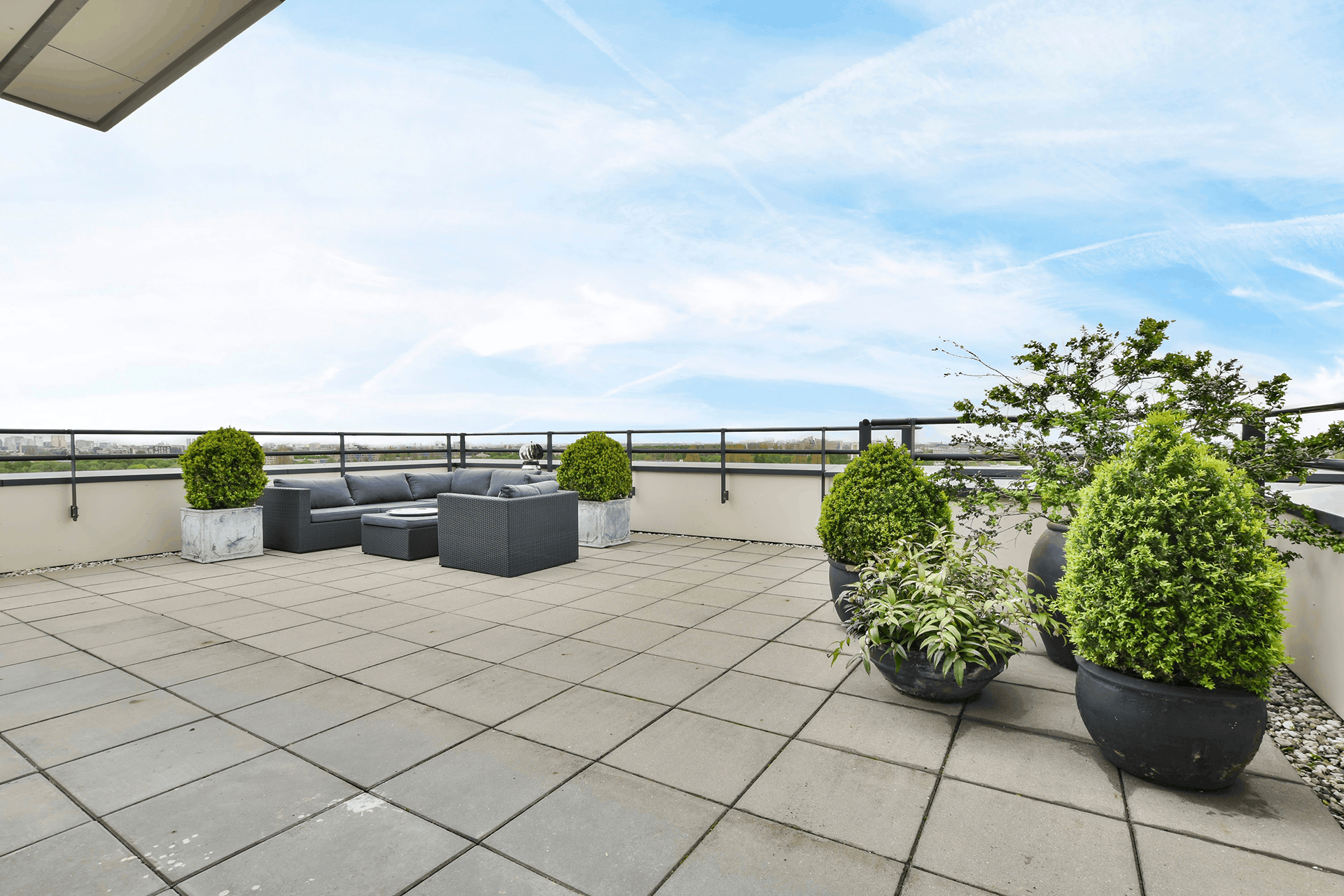 Abgedichtete und mit Platten belegte Dachterrasse mit Sitzgruppe und Kübelpflanzen